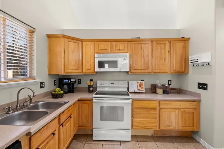 Kitchen featuring white appliances, light countertops, and light tile patterned floors