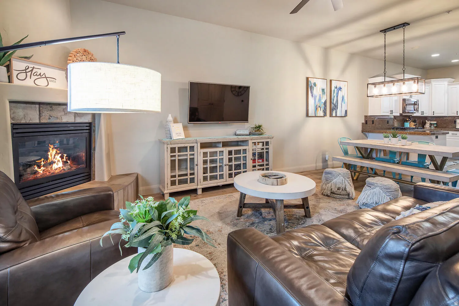 Living room featuring a glass covered fireplace, ceiling fan, and recessed lighting