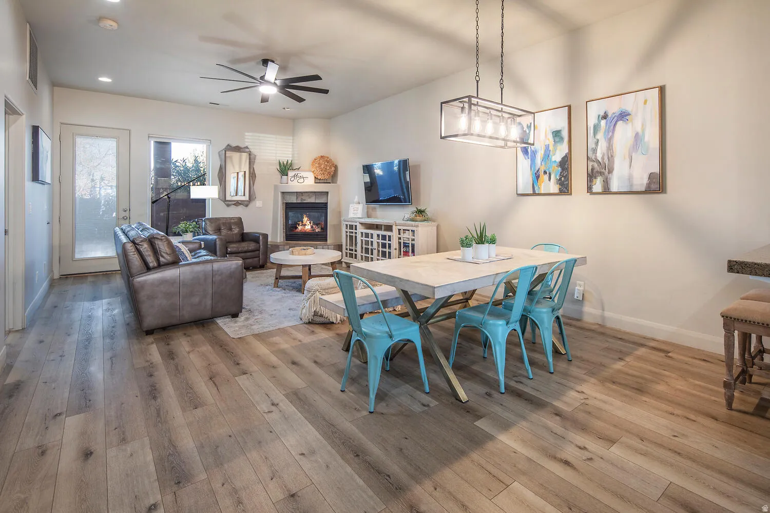 Dining area with a ceiling fan, light wood-style flooring, a tiled fireplace, and recessed lighting