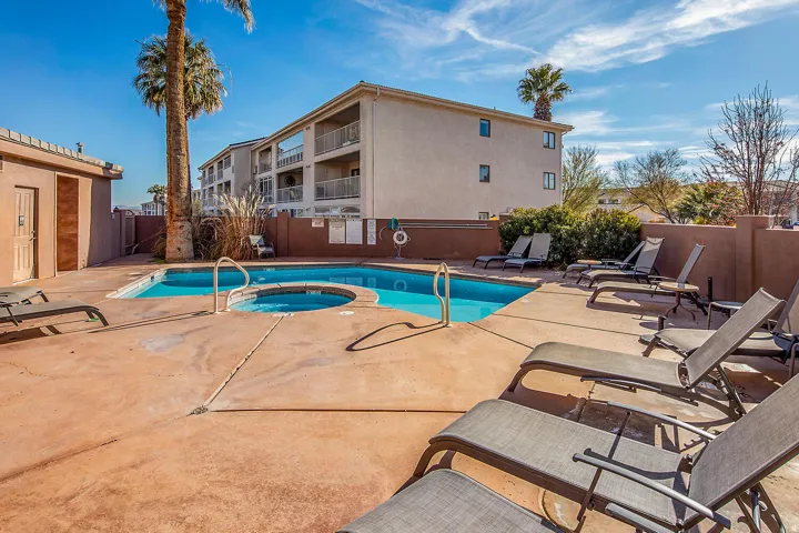 Community pool with a patio area and a hot tub