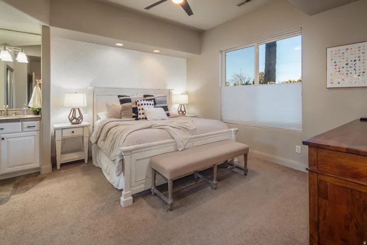 Bedroom with light colored carpet, ceiling fan, connected bathroom, and recessed lighting