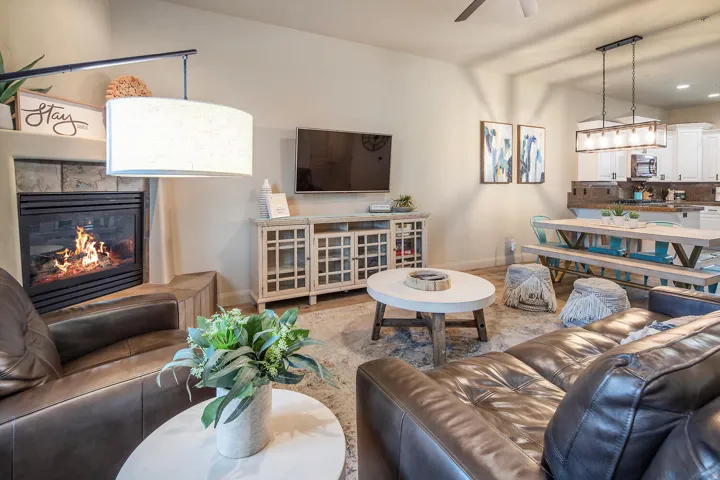 Living room featuring a glass covered fireplace, ceiling fan, and recessed lighting