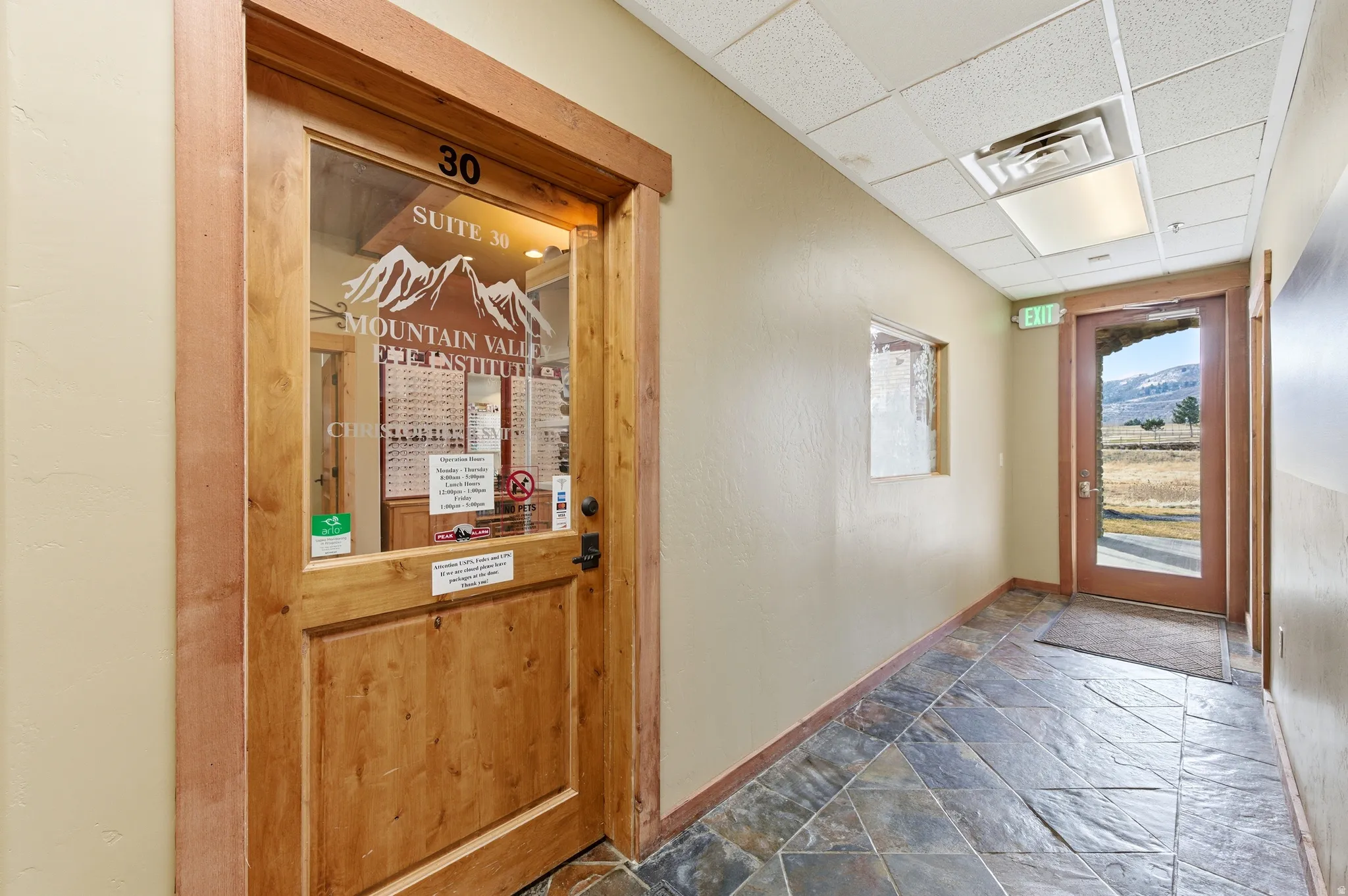 Hall with stone tile flooring, a paneled ceiling, and a mountain view