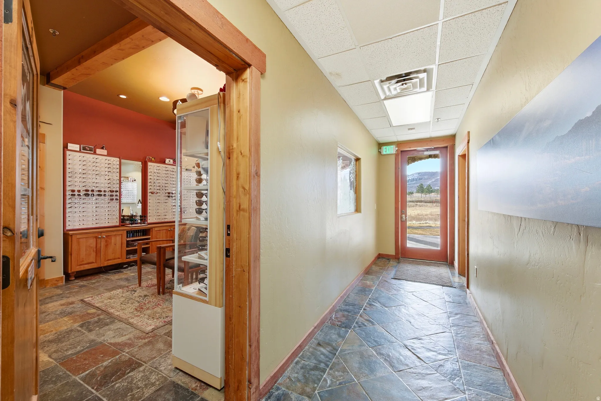 Hallway with stone tile floors and a drop ceiling