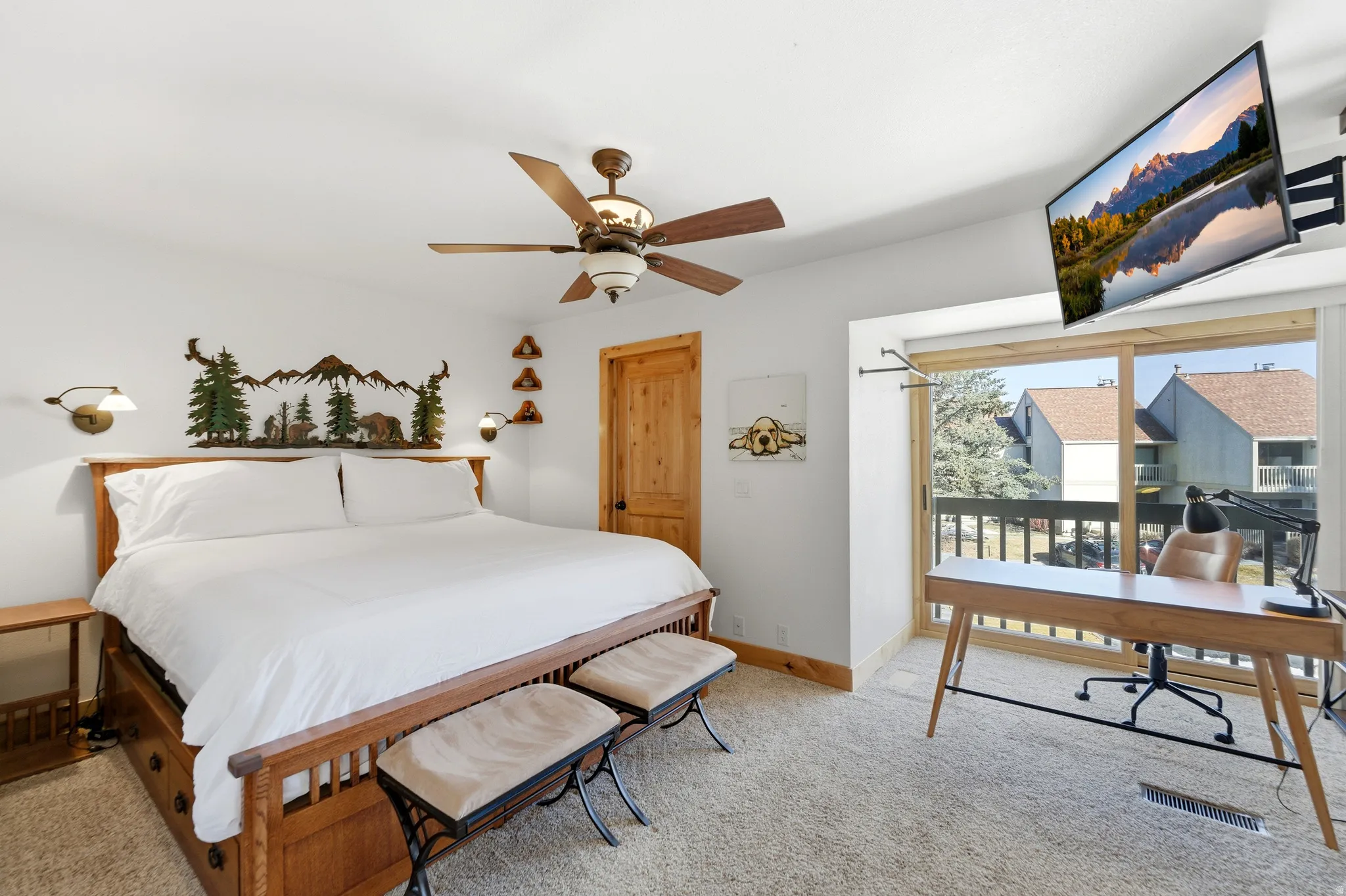 Bedroom with an office area, light carpet, ceiling fan, and access to outside