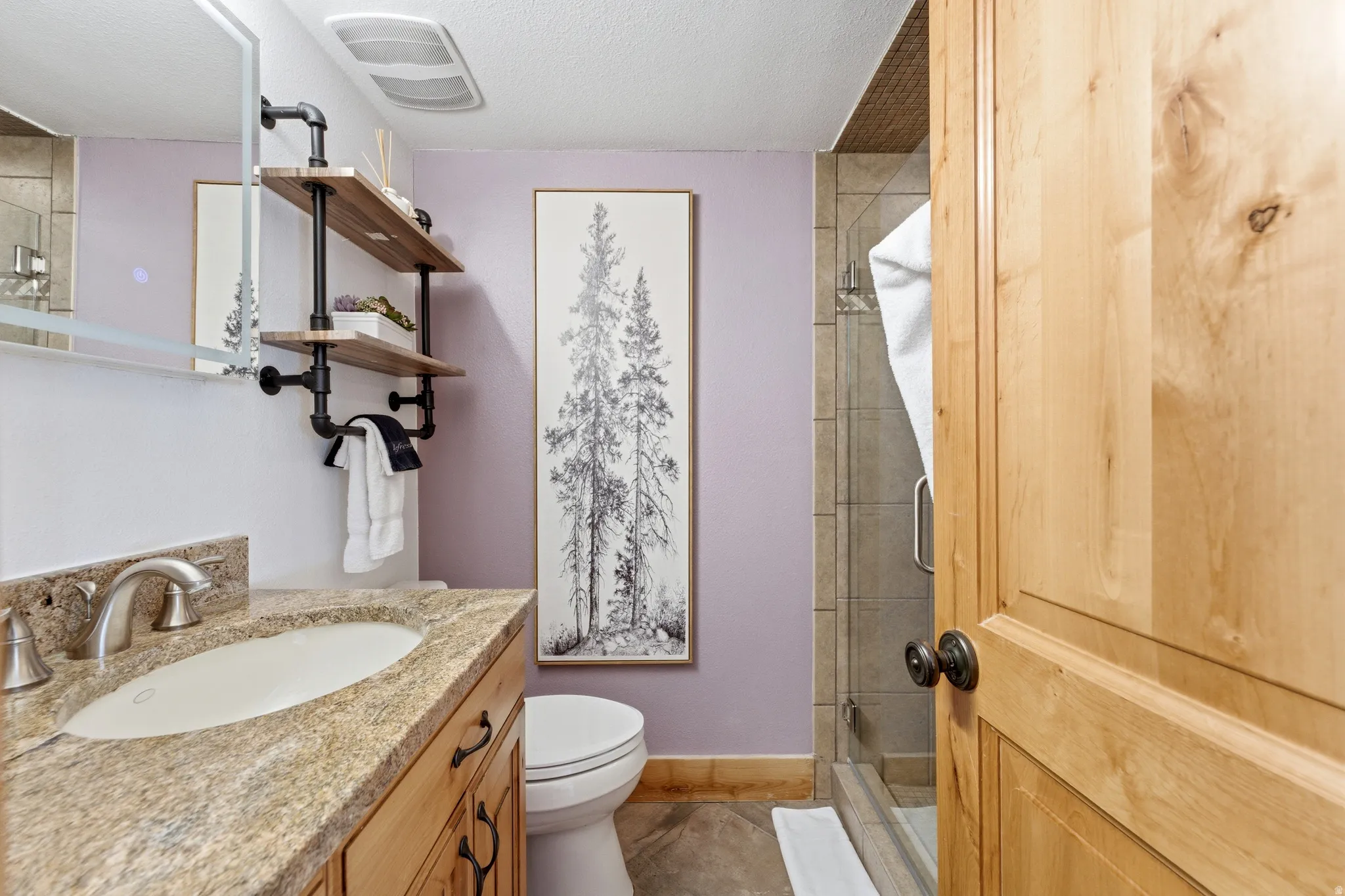 Bathroom featuring a stall shower, vanity, and a textured ceiling