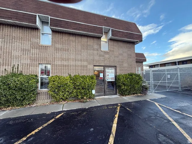 View of building exterior featuring uncovered parking