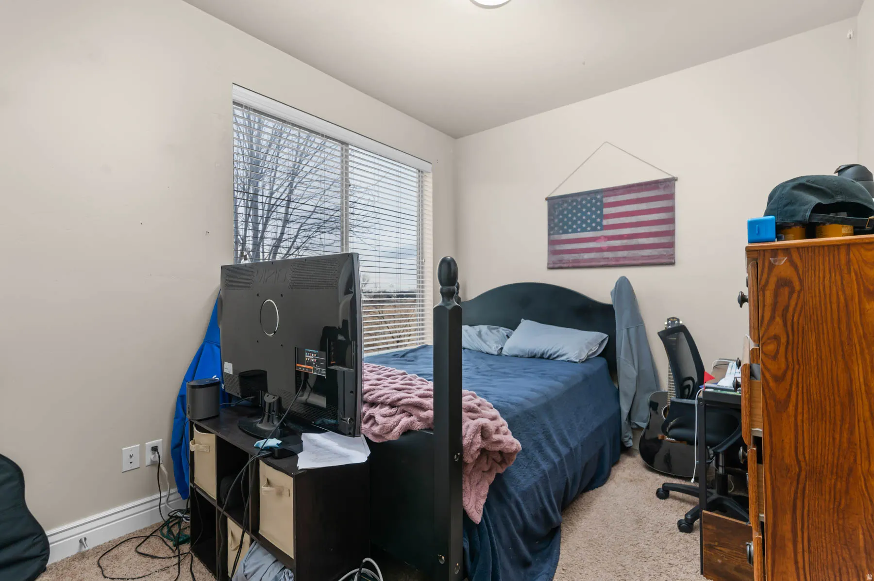 Bedroom with a desk and light carpet