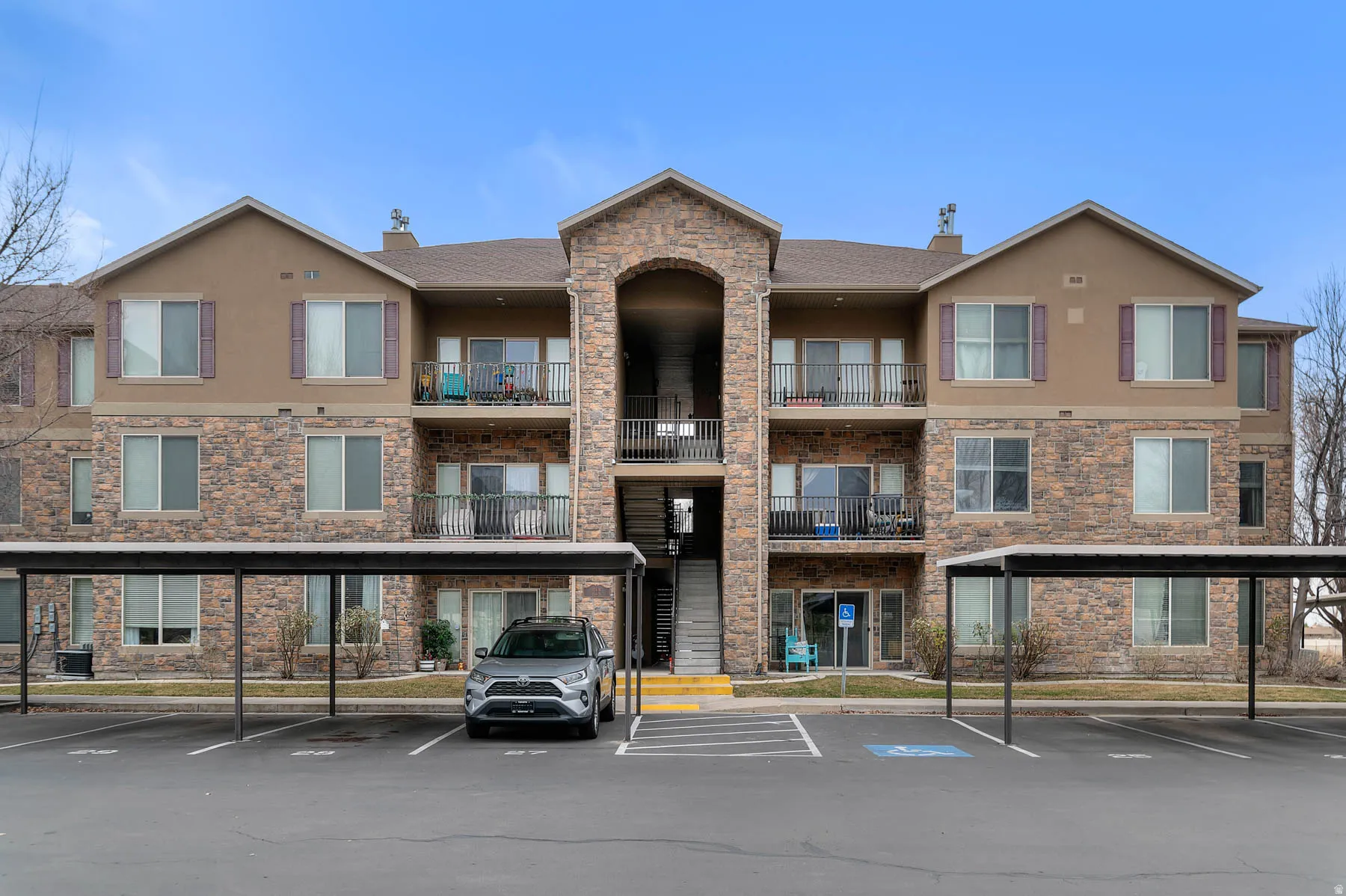 View of apartment building / complex with covered parking