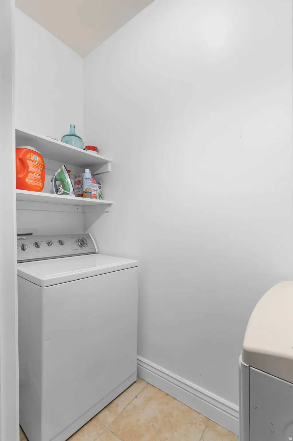 Laundry room with light tile patterned floors and washing machine and clothes dryer