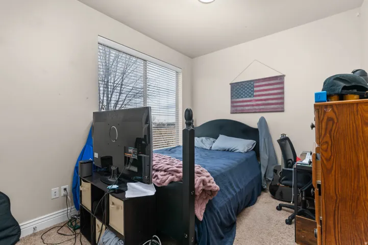 Bedroom with a desk and light carpet