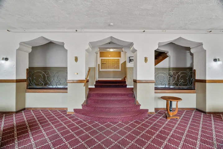 Stairs with carpet and a textured ceiling