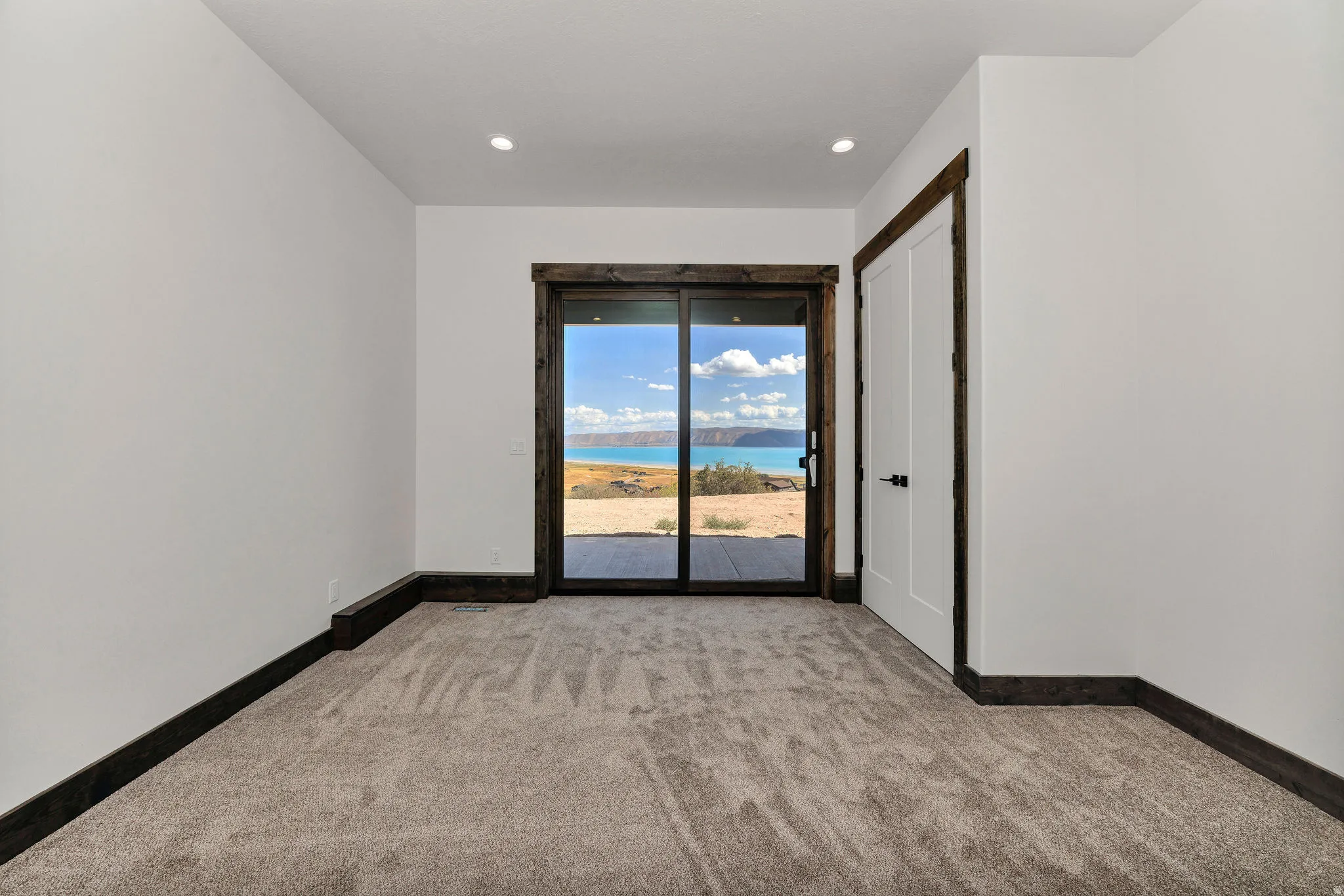 Empty room with baseboards and light carpet