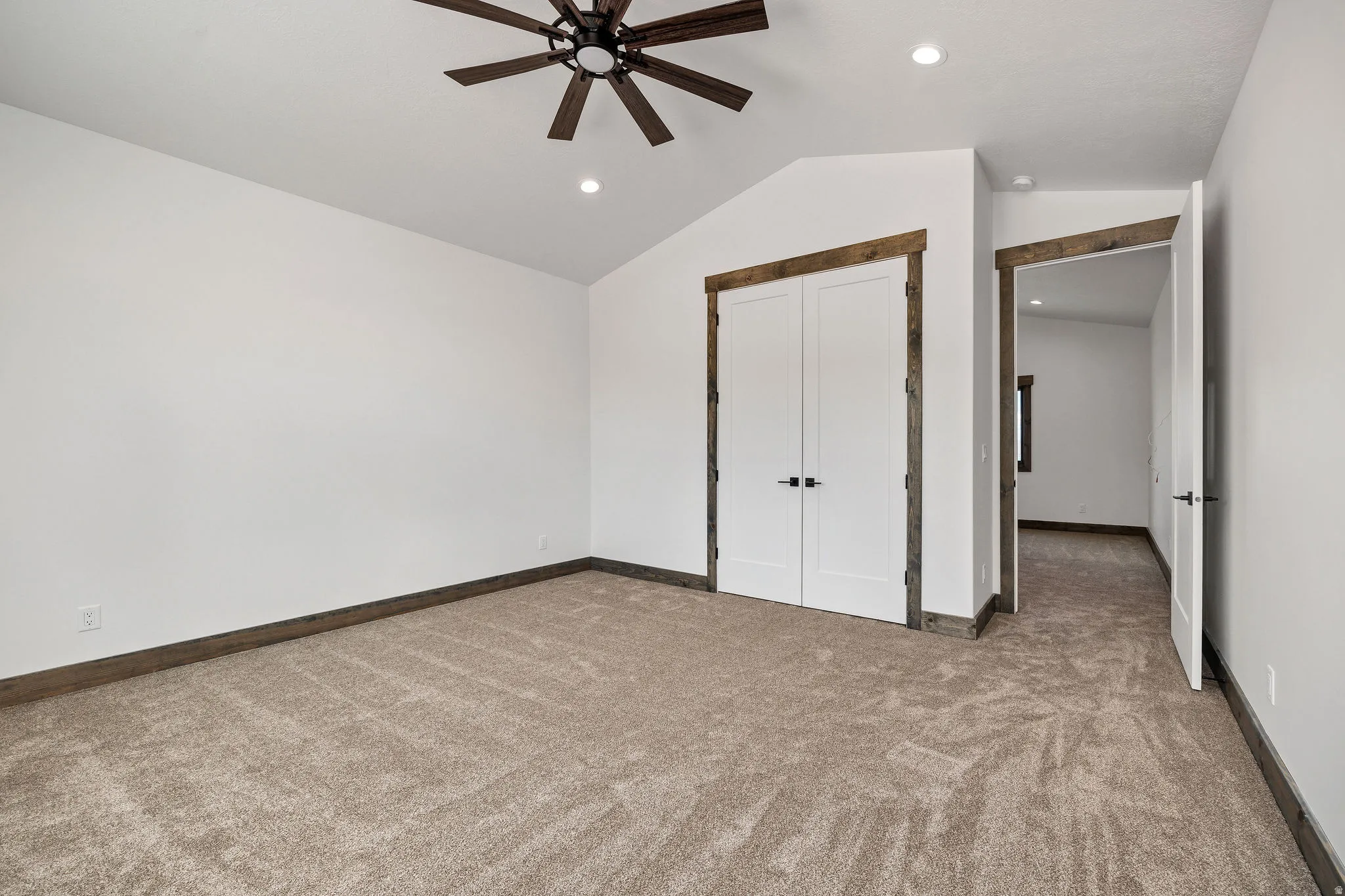 Unfurnished bedroom featuring light colored carpet, a ceiling fan, a closet, and recessed lighting