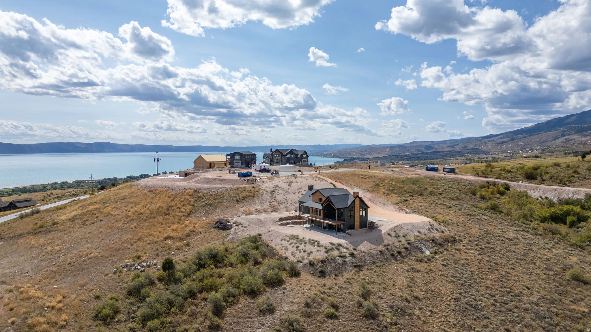 Aerial view of property and surrounding area featuring a water and mountain view