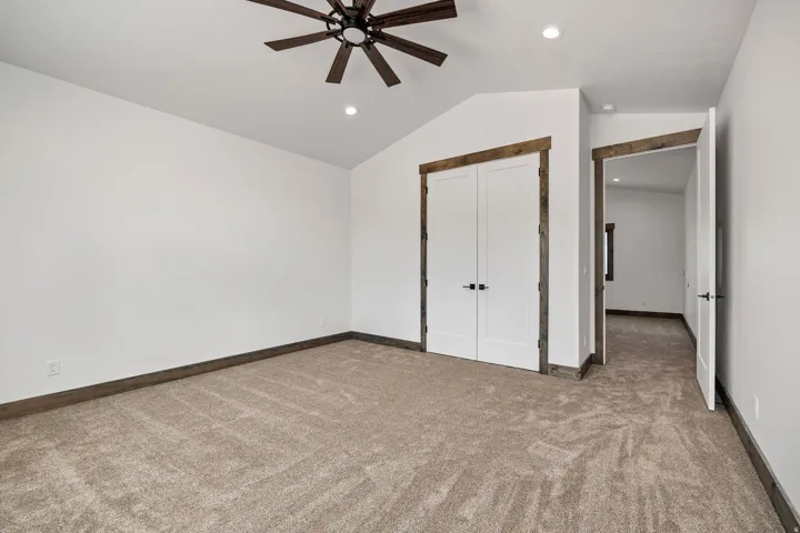 Unfurnished bedroom featuring light colored carpet, a ceiling fan, a closet, and recessed lighting