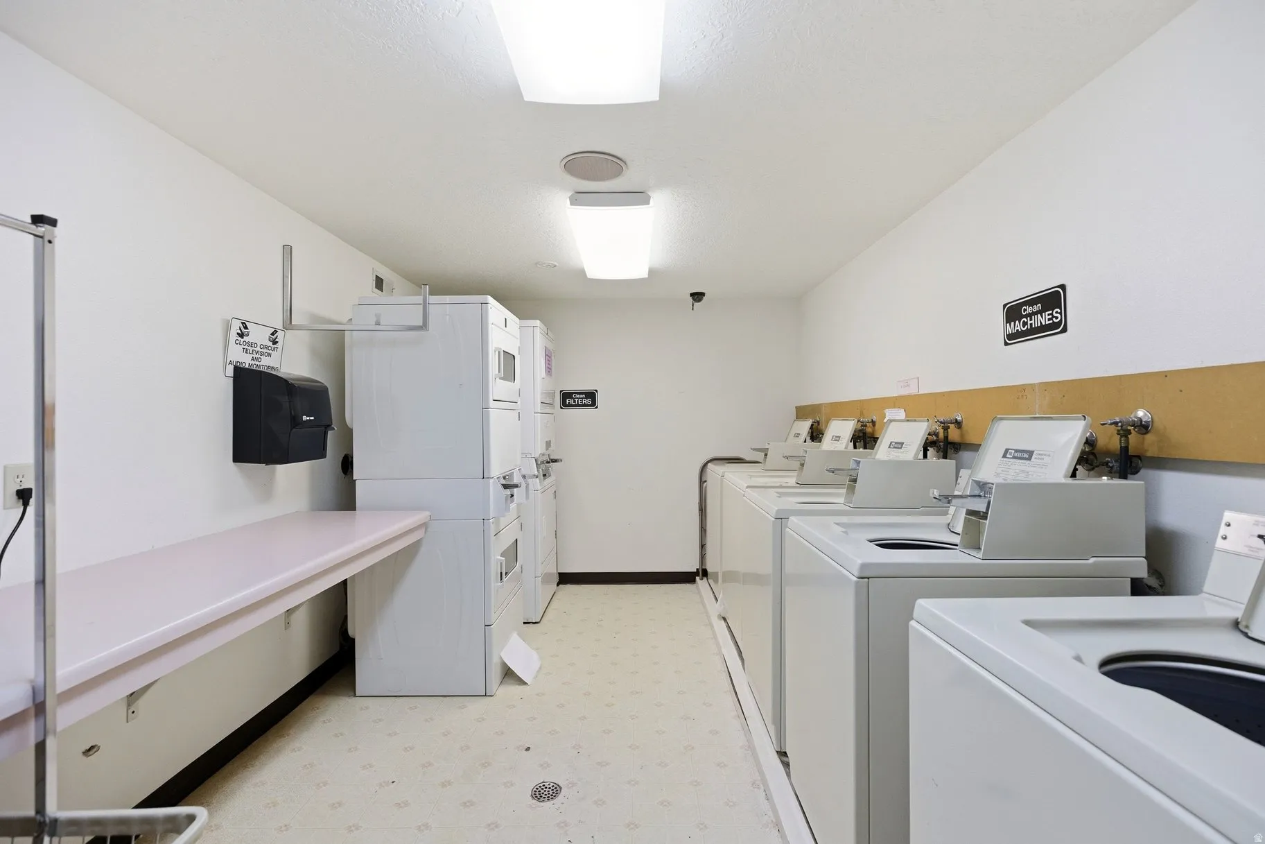 Communal laundry room with separate washer and dryer