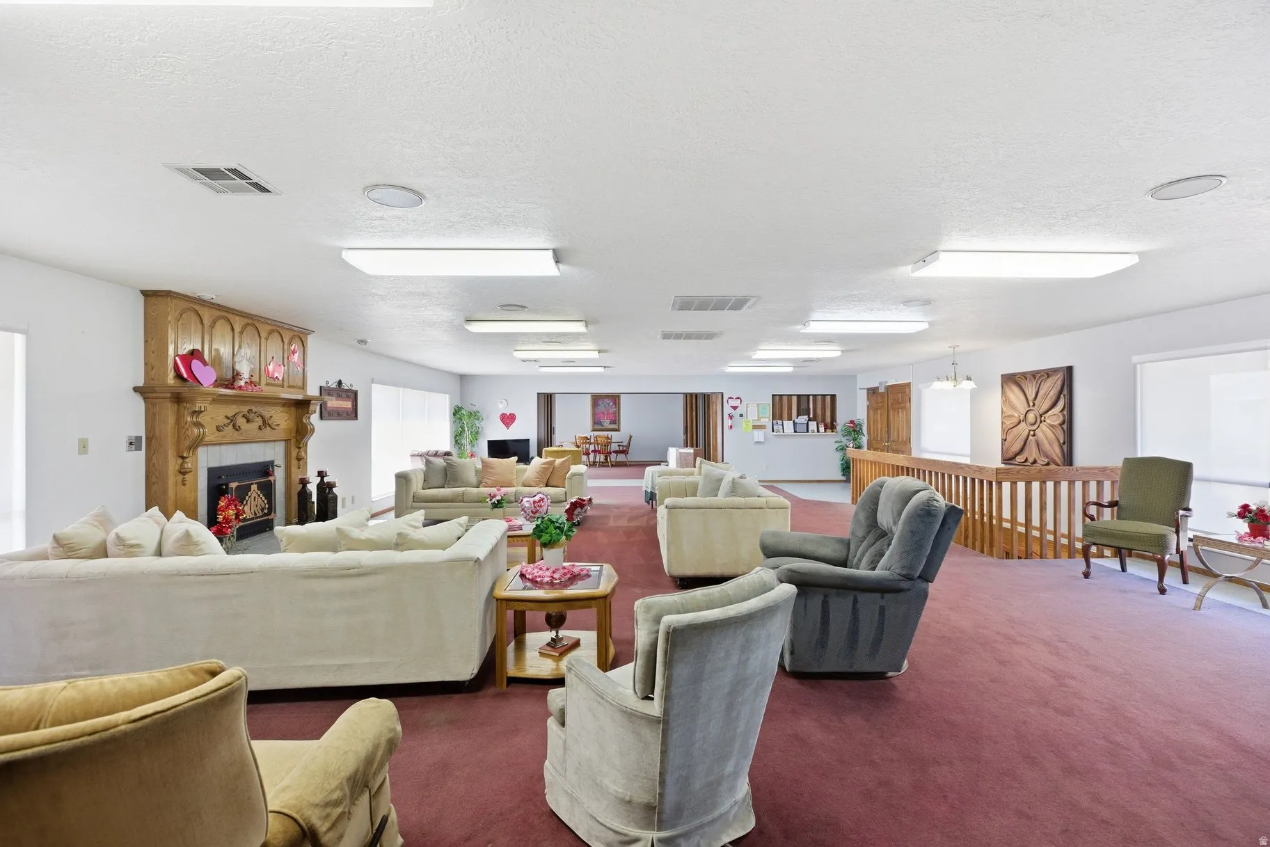 Carpeted living room featuring a fireplace and a textured ceiling