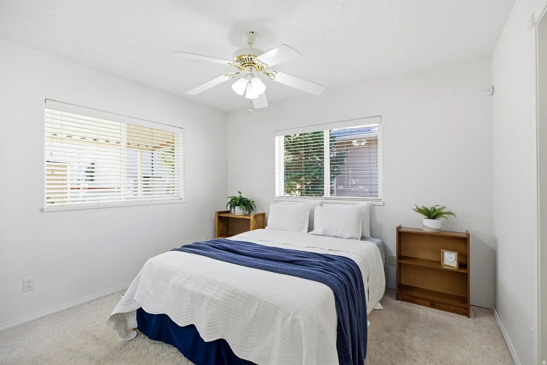 Bedroom with light colored carpet and a ceiling fan