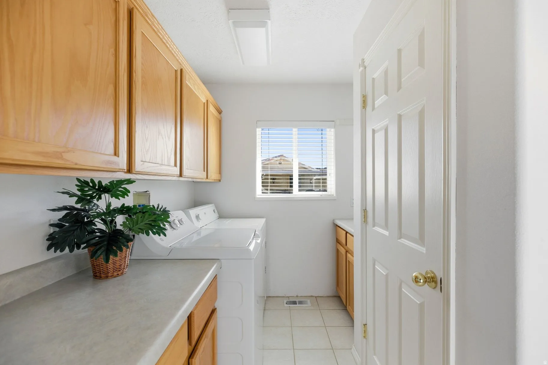 Laundry room with cabinet space, washing machine and dryer, and light tile patterned floors