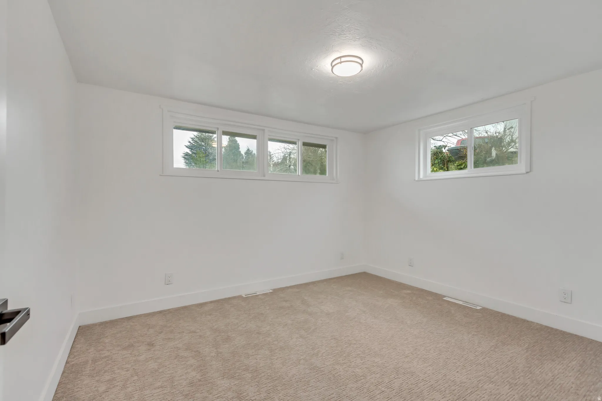 Carpeted spare room featuring baseboards