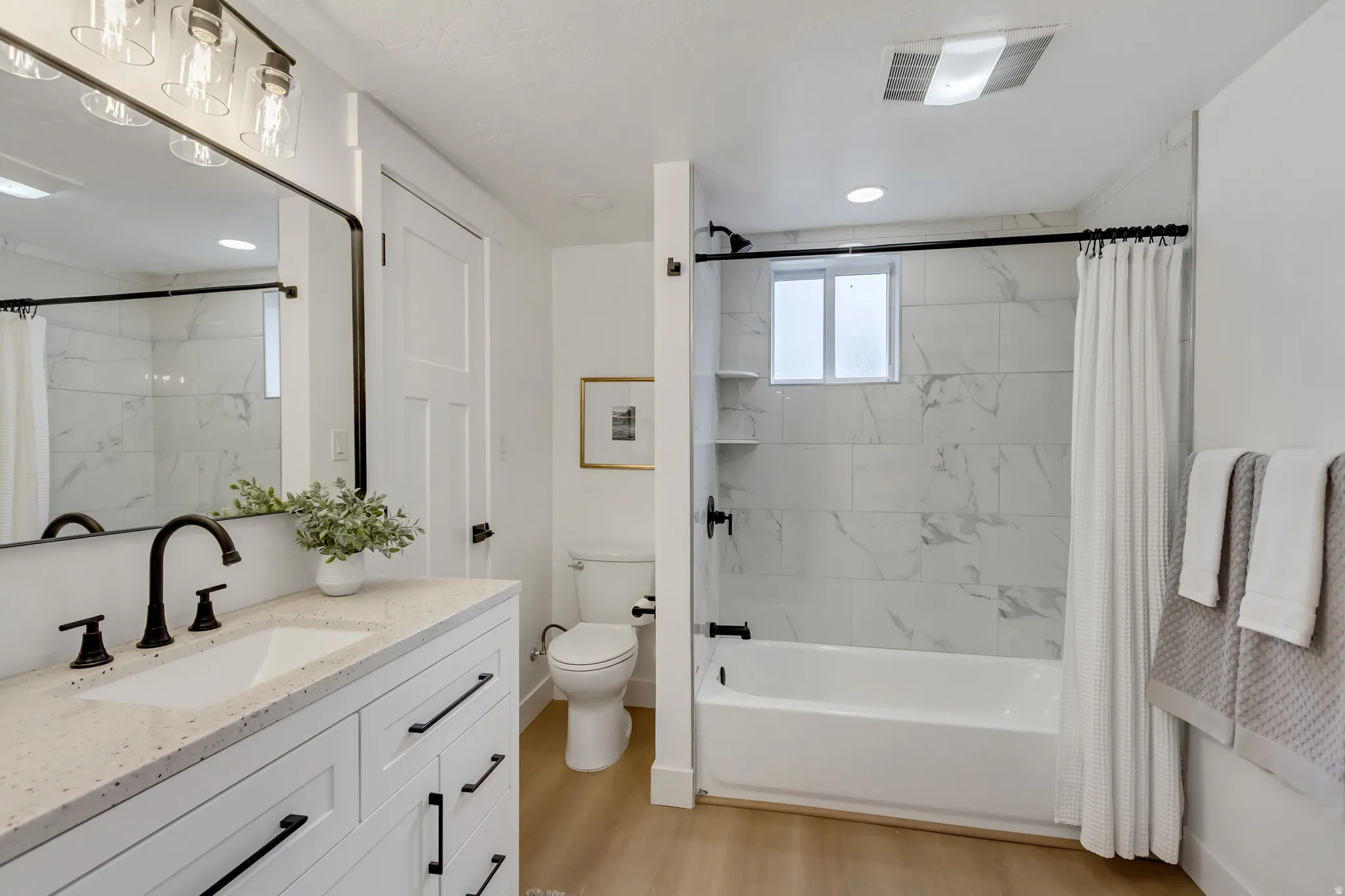 Bathroom with vanity, shower / bath combo with shower curtain, light wood-style flooring, and recessed lighting