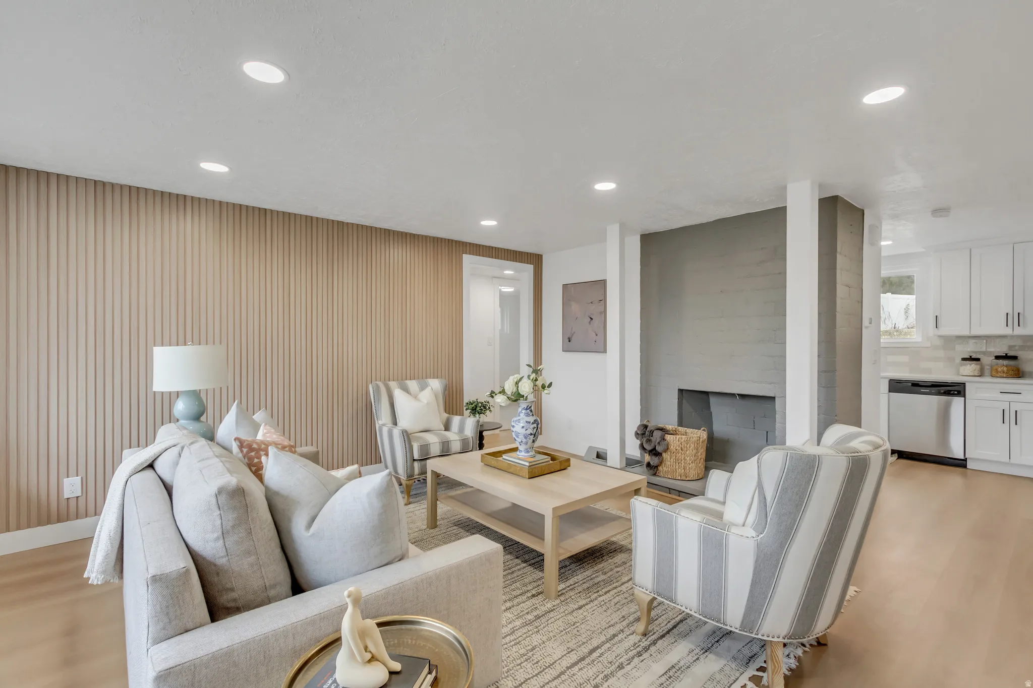 Living area featuring light wood finished floors, a fireplace, and recessed lighting