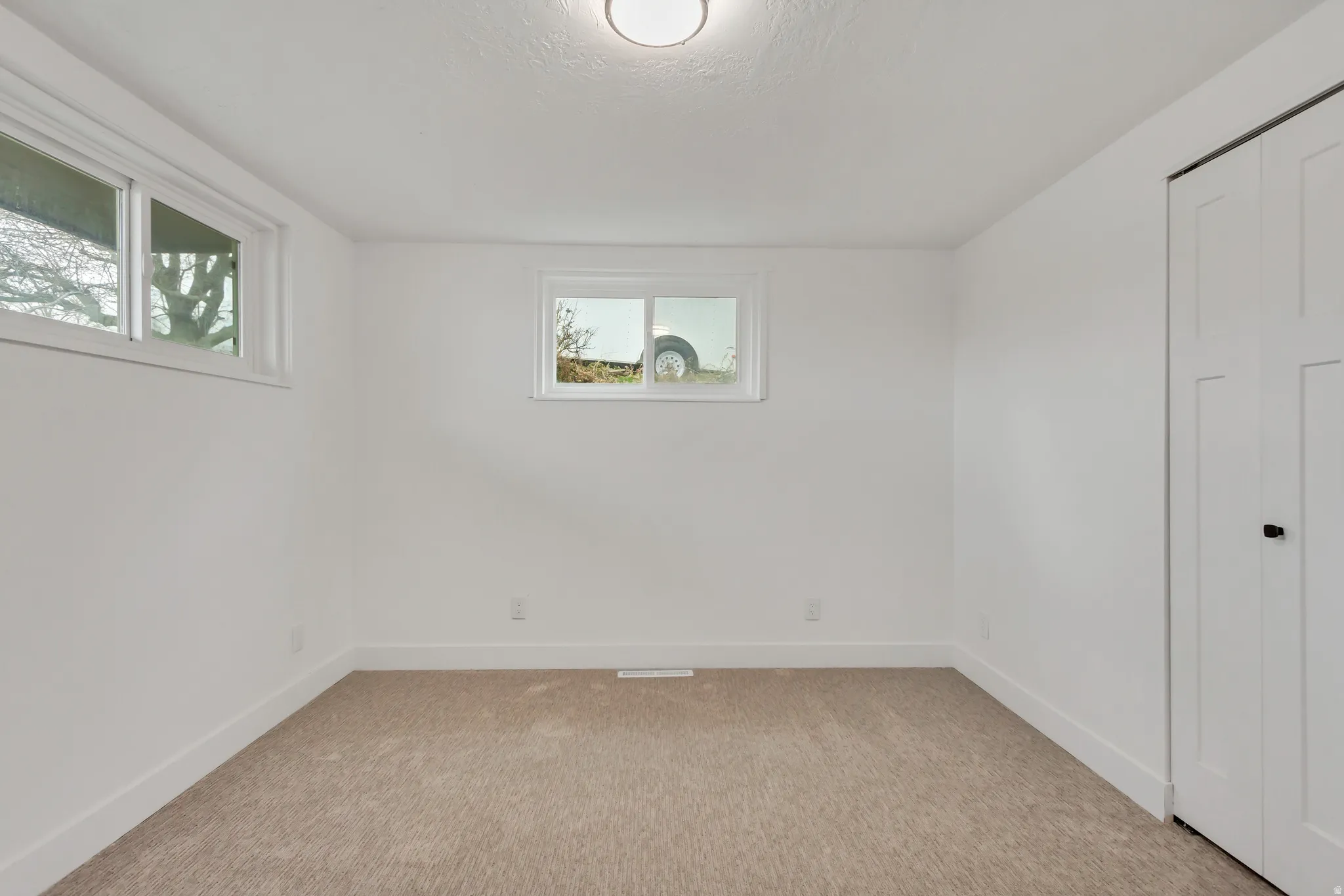 Unfurnished bedroom with light colored carpet and a closet