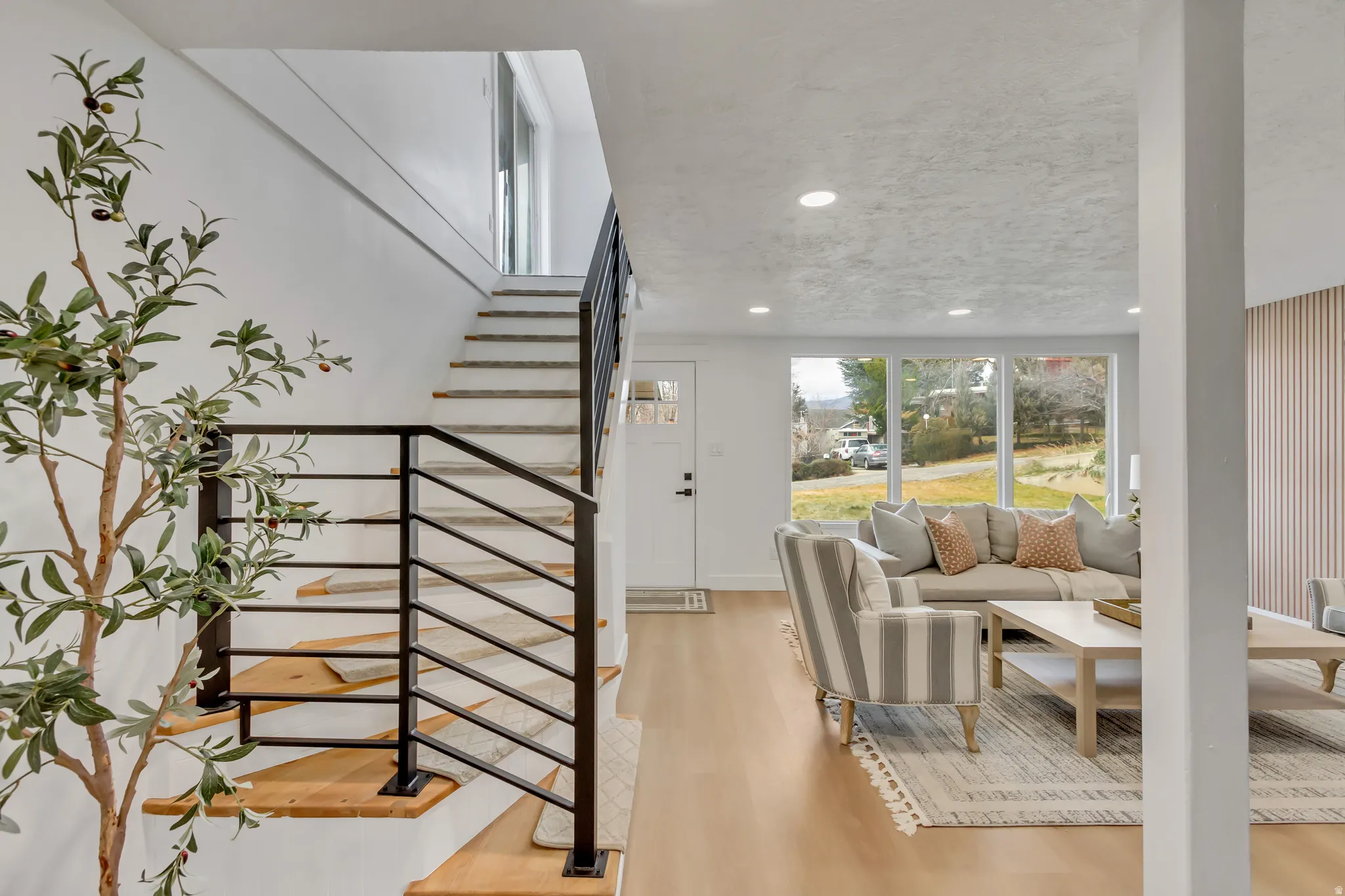 Stairs with wood finished floors and recessed lighting