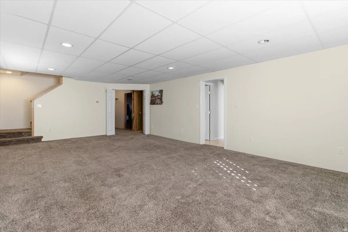 Finished basement featuring carpet flooring, a drop ceiling, and recessed lighting