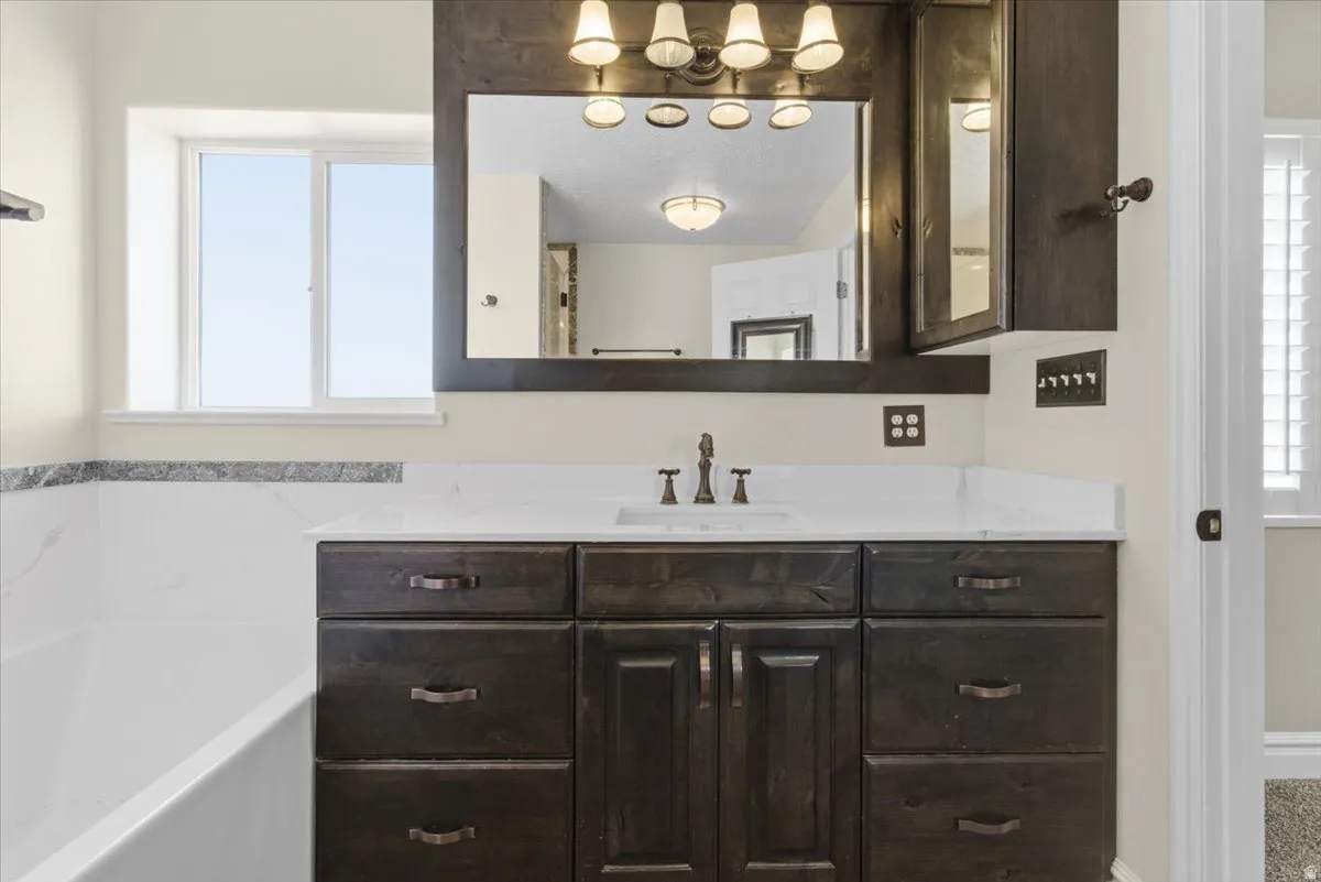 Full bath with vanity, a bath, and plenty of natural light