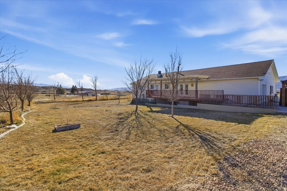 Rear view of house with a yard and a deck