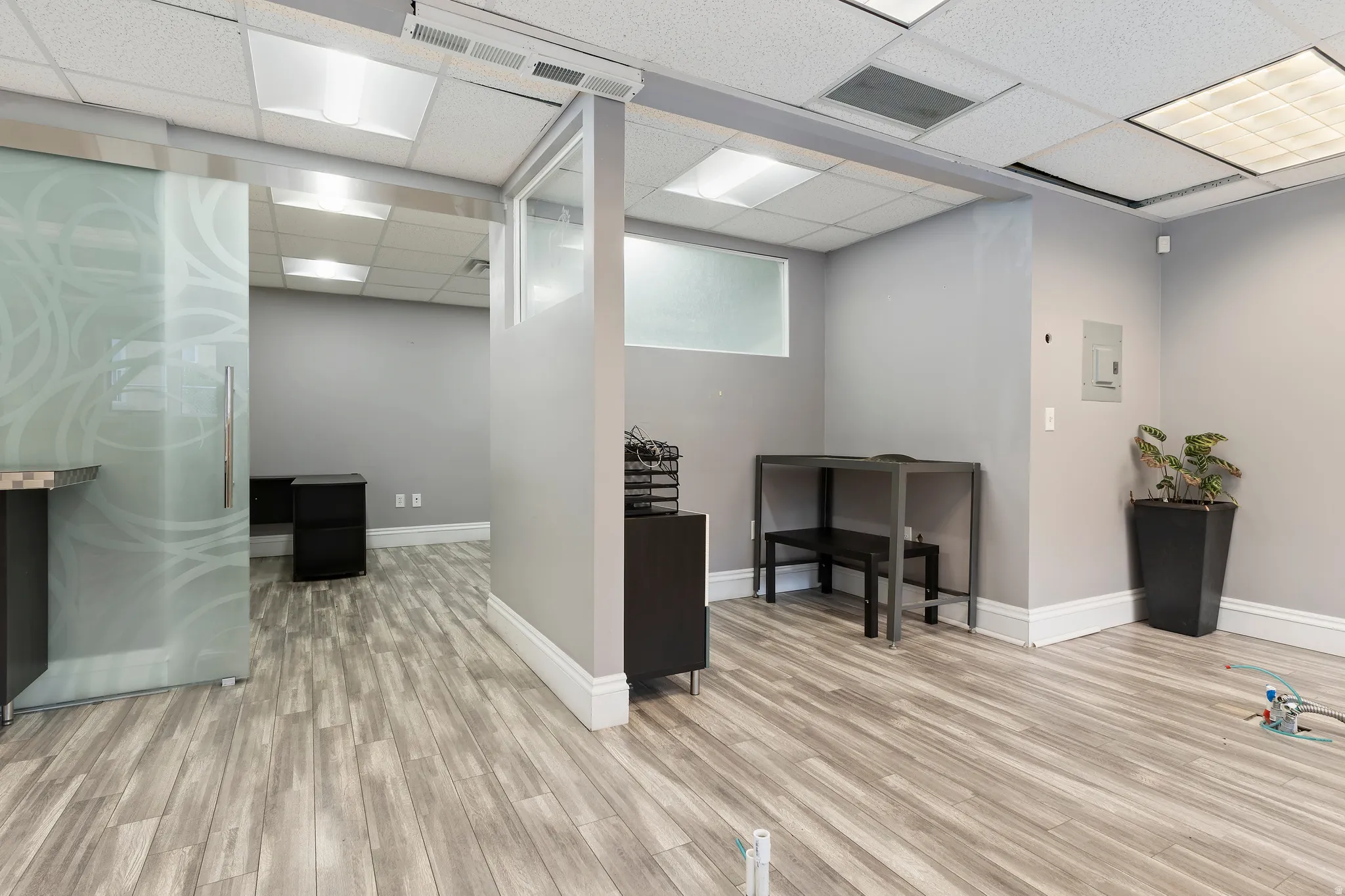 Office space featuring a drop ceiling and electric panel