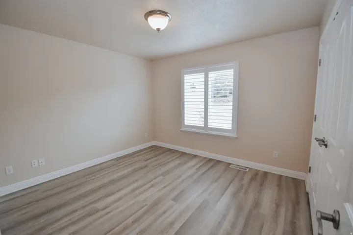 Empty room with light wood-type flooring and baseboards