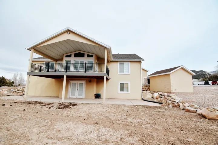Rear view of property featuring a patio, french doors, stucco siding, and a deck