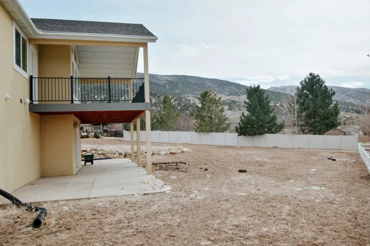 Fenced yard featuring a mountain view and a patio