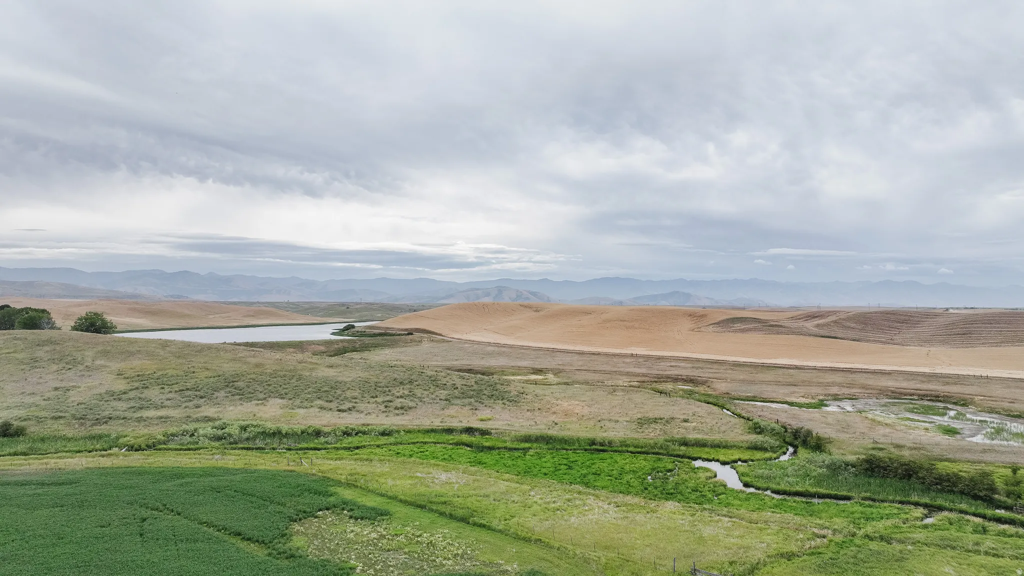 View of mountain background featuring a nearby body of water and rural landscape