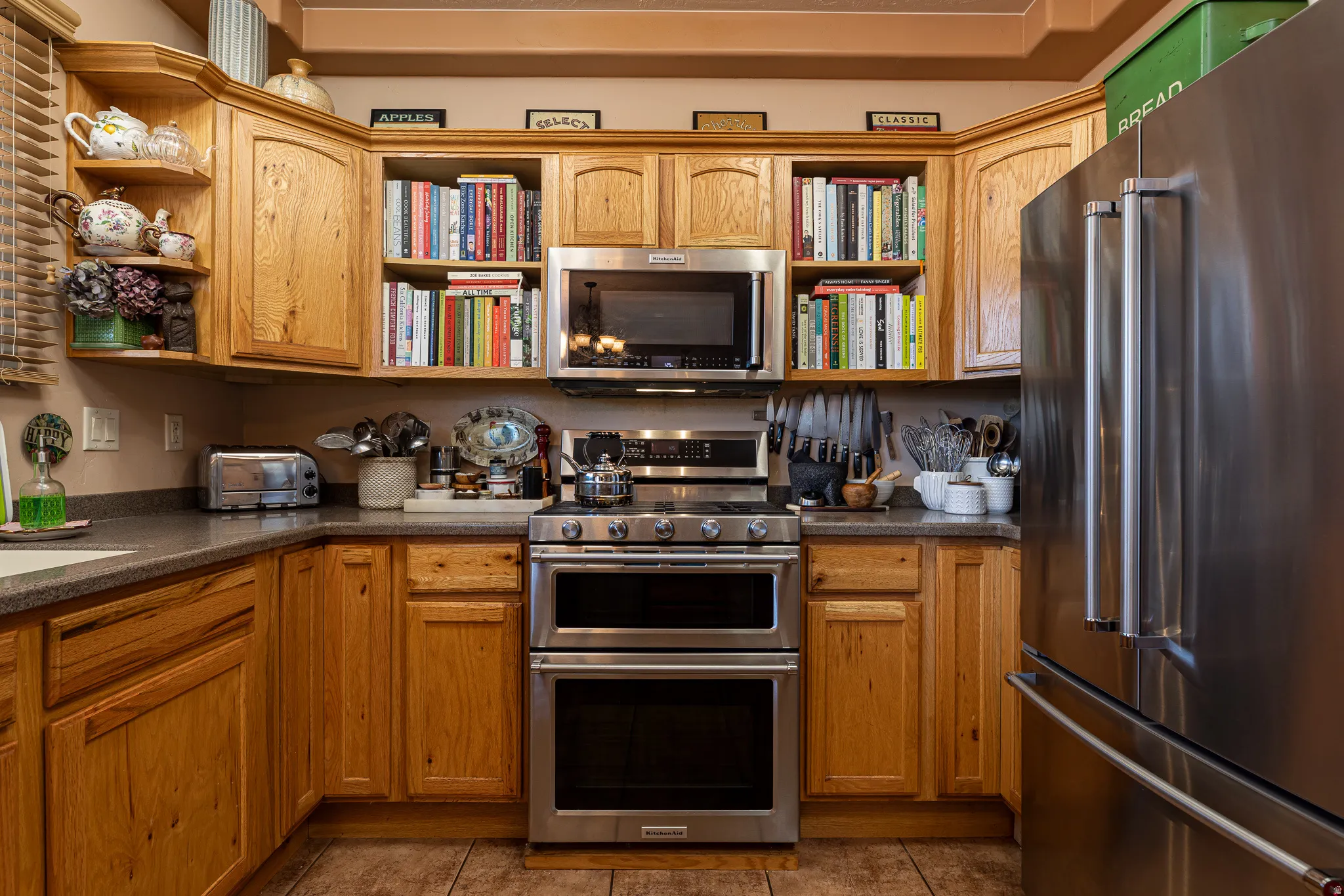 Kitchen featuring stainless steel appliances, open shelves, and wood finish cabinets