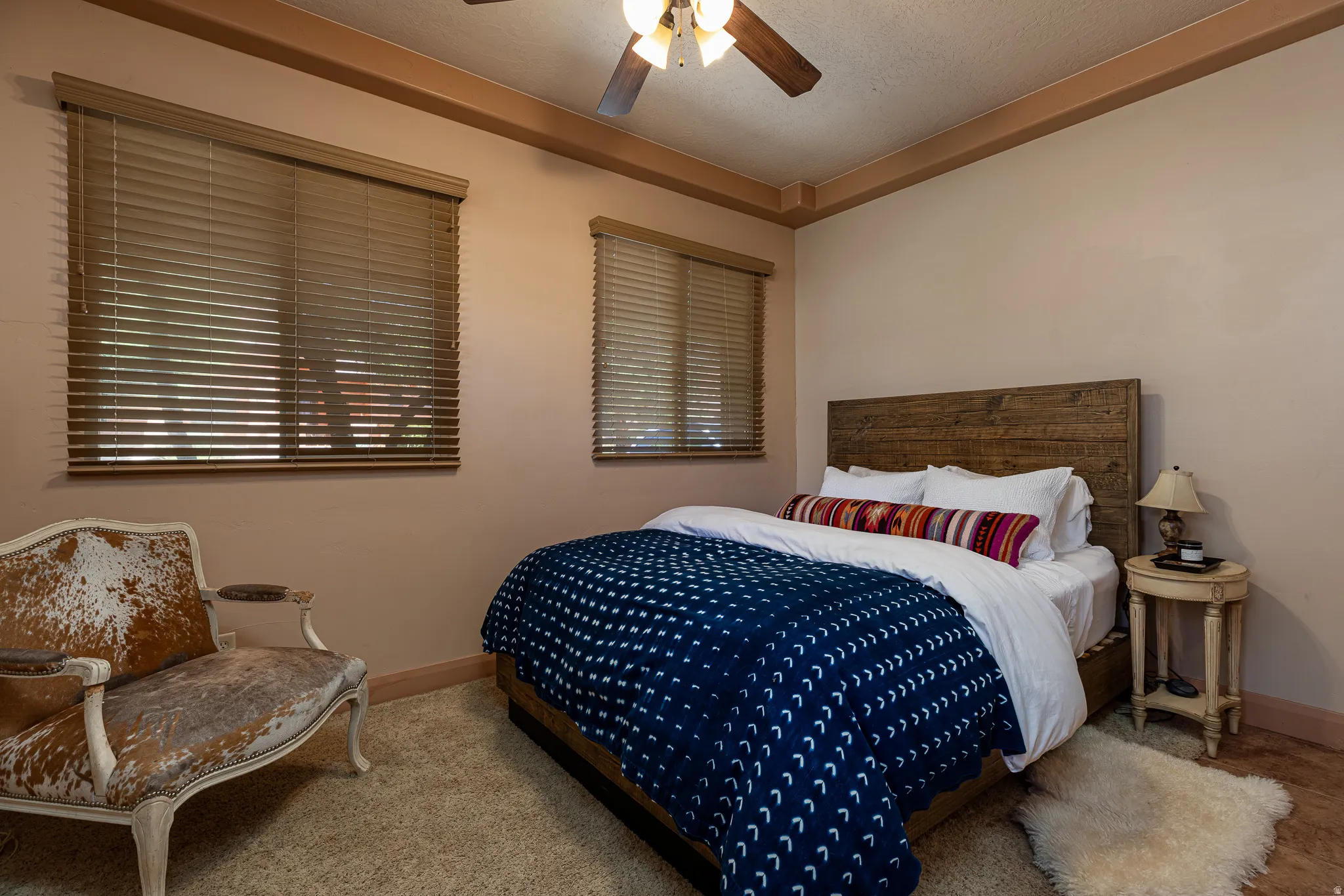 Carpeted bedroom featuring a ceiling fan and a textured ceiling