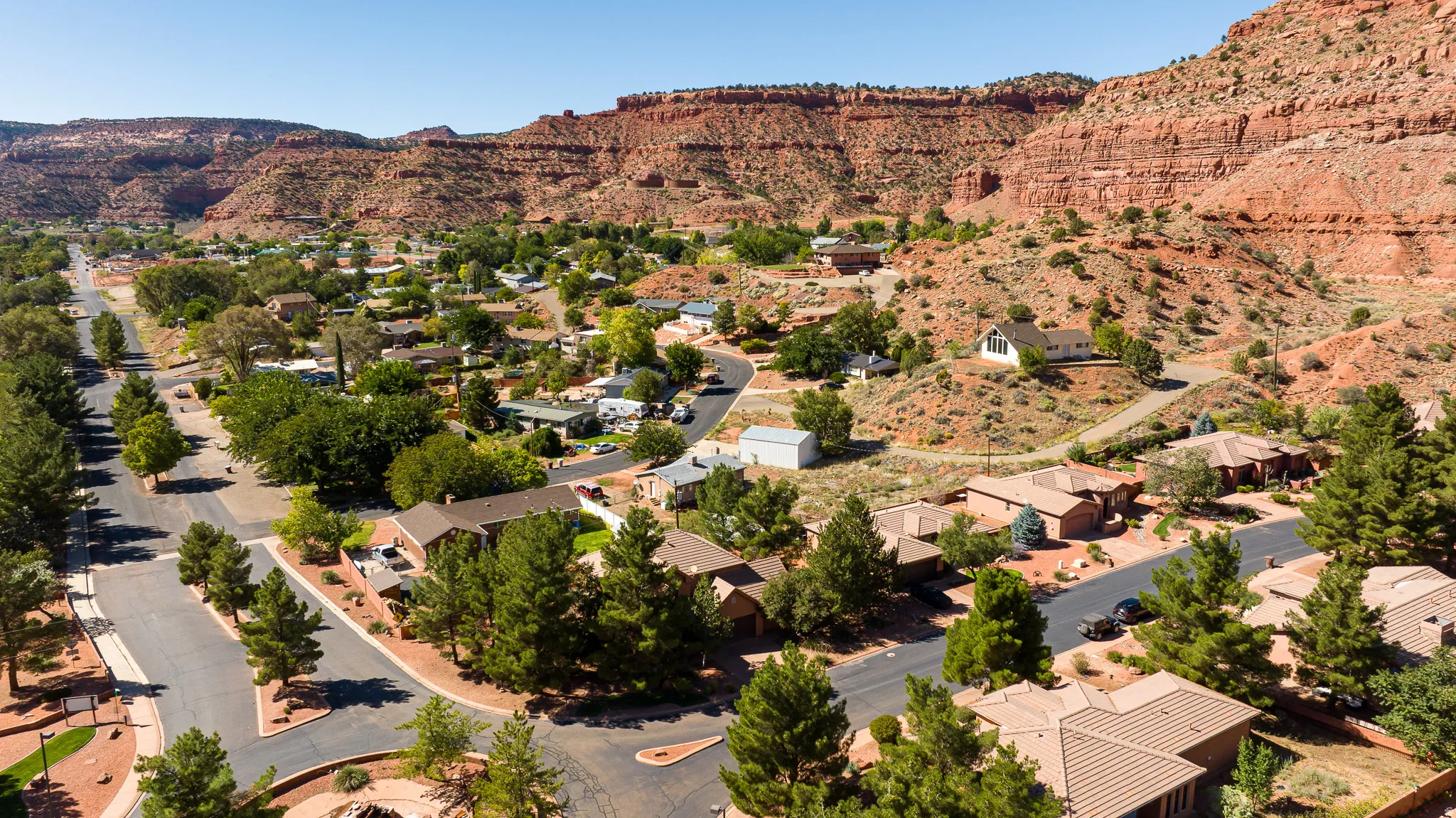 Aerial view of property and surrounding area featuring a mountain backdrop and nearby suburban area