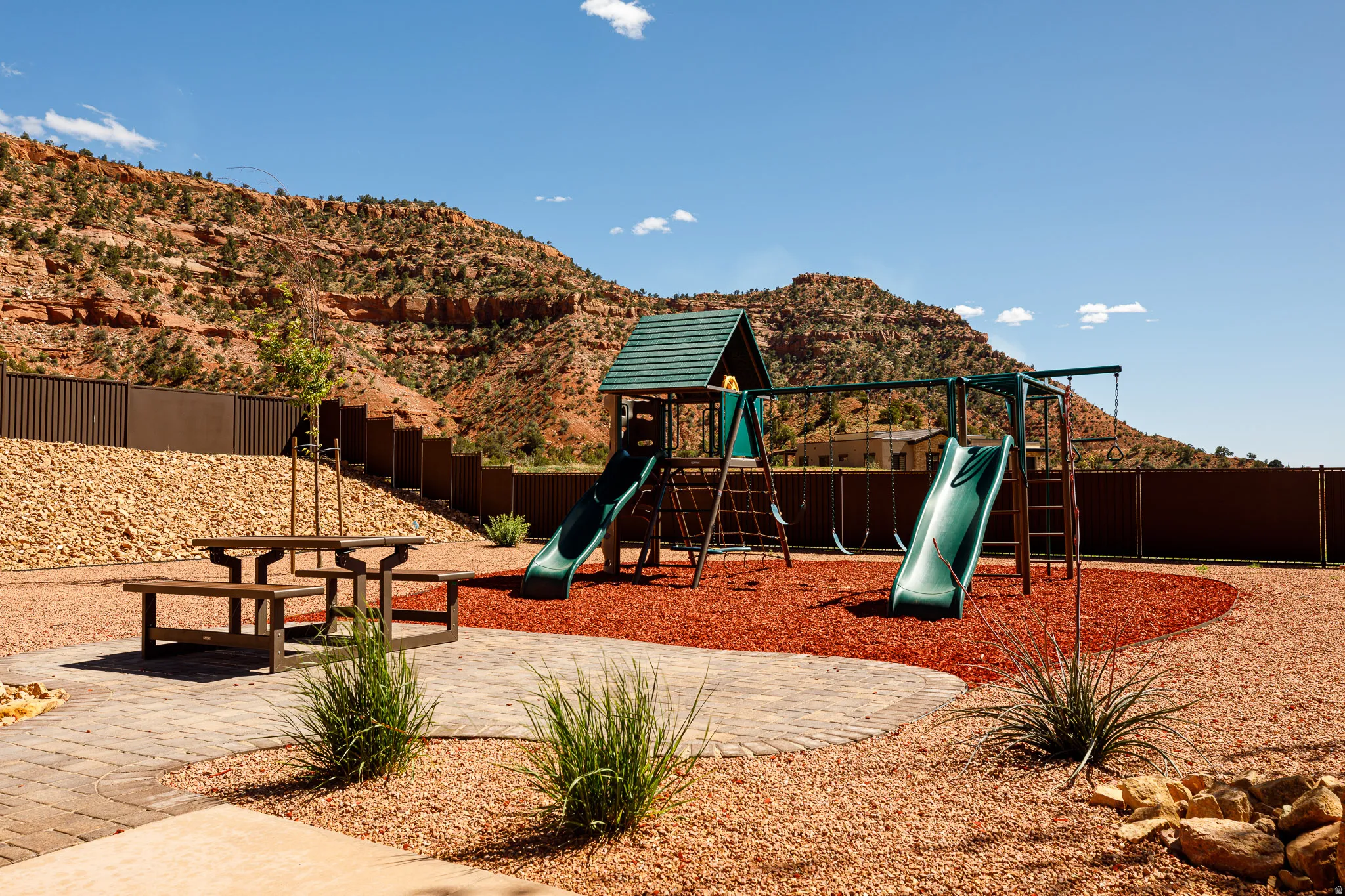 Communal playground featuring a mountain view and a patio area