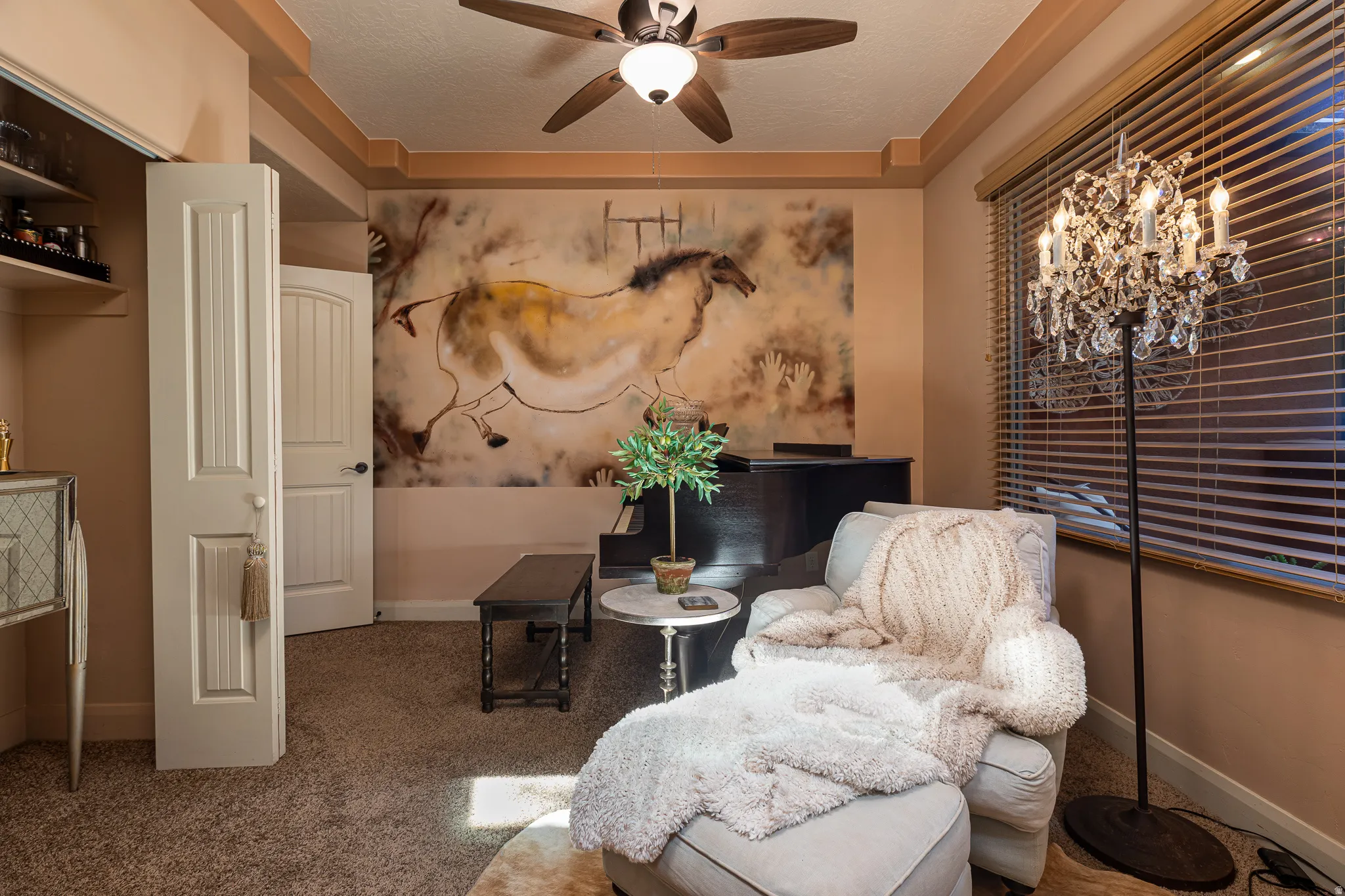 Living area with ceiling fan, carpet flooring, and a textured ceiling