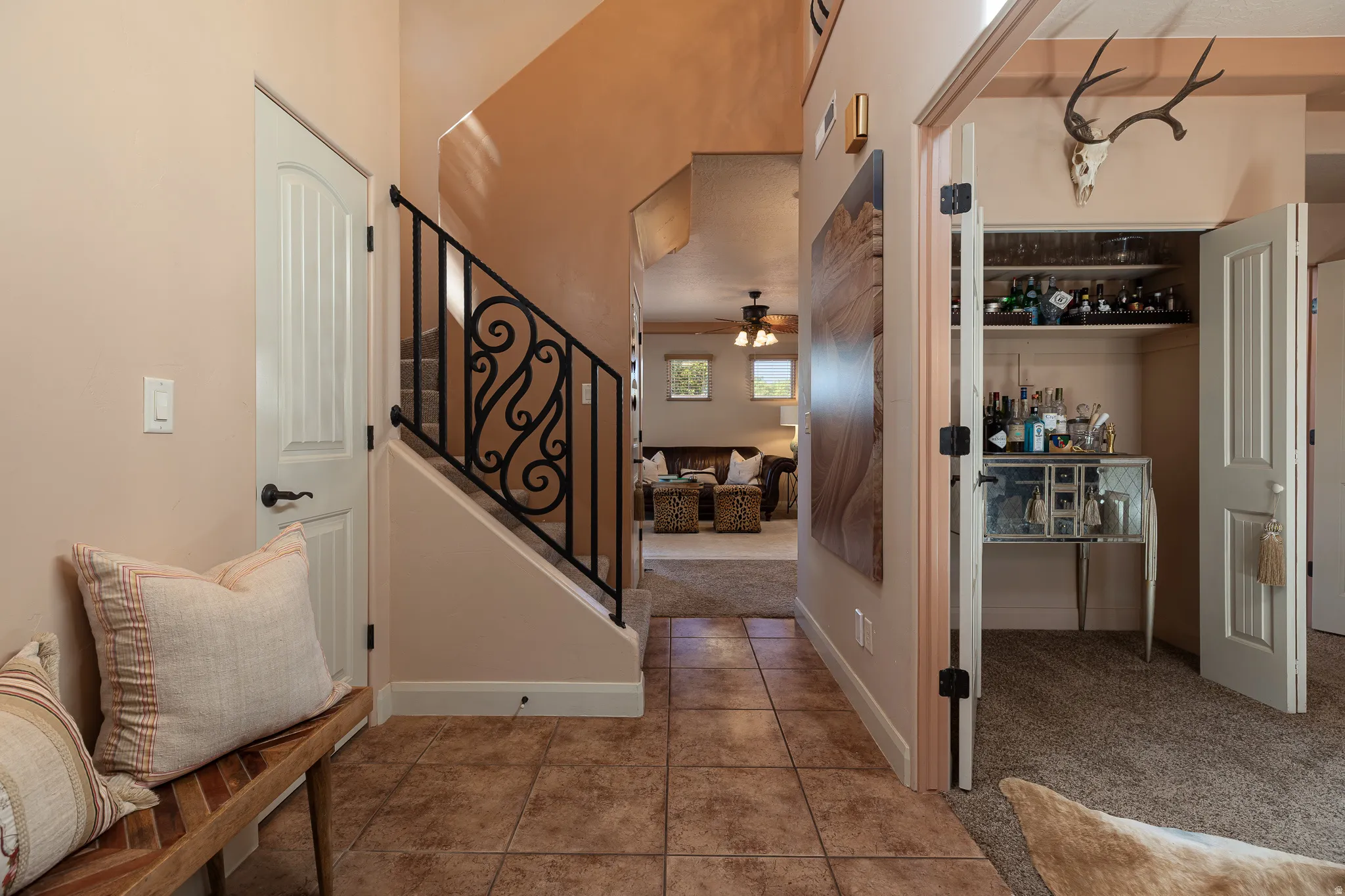 Foyer entrance featuring light colored carpet and ceiling fan