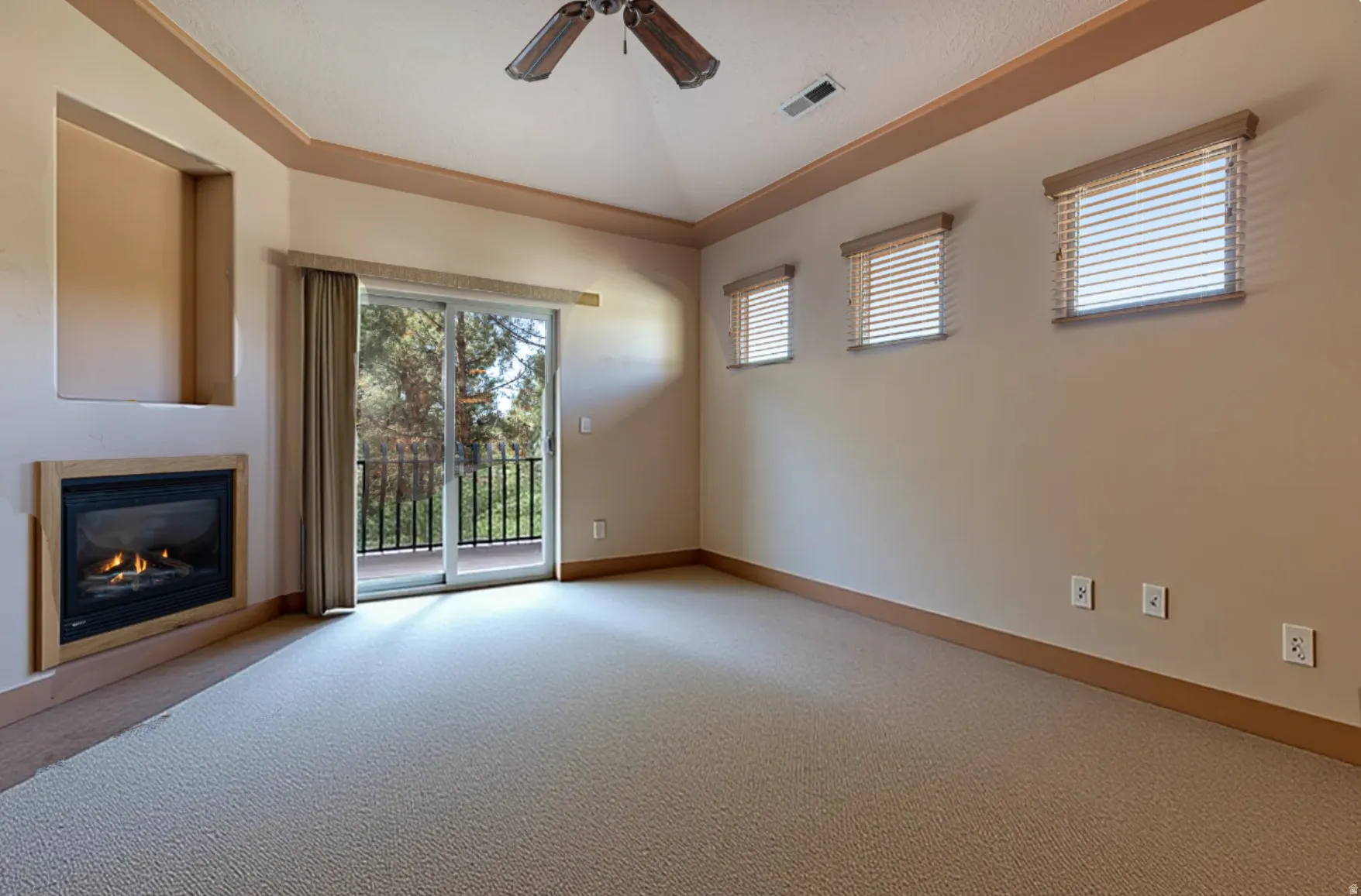 Unfurnished living room with carpet flooring, a glass covered fireplace, ceiling fan, plenty of natural light, and lofted ceiling