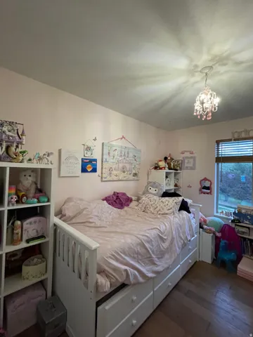 Bedroom with dark wood-style floors and a chandelier