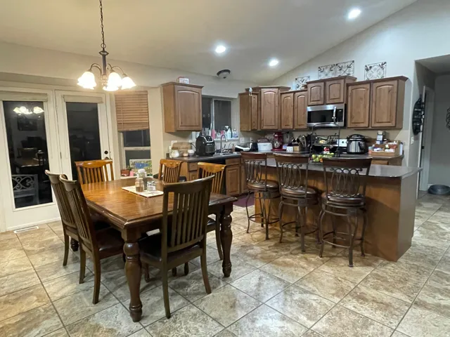 Dining space featuring vaulted ceiling and hanging lights