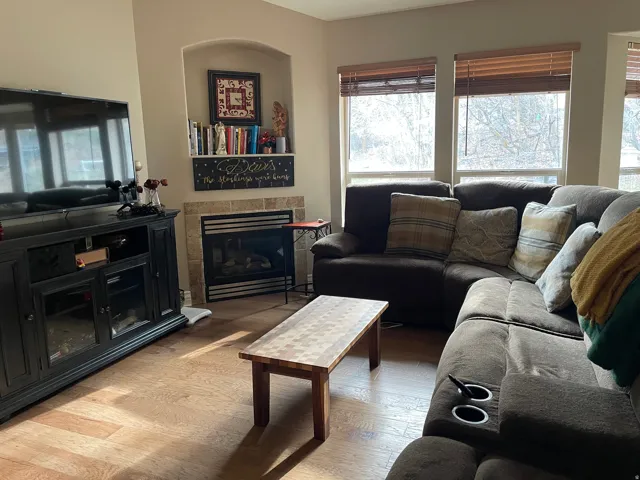 Living area with light wood-style flooring and a tiled fireplace