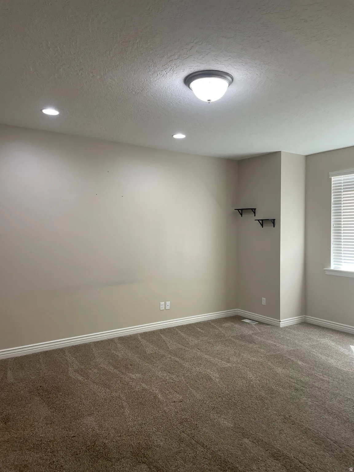 Primary Bedroom featuring a textured ceiling, carpet, and recessed lighting