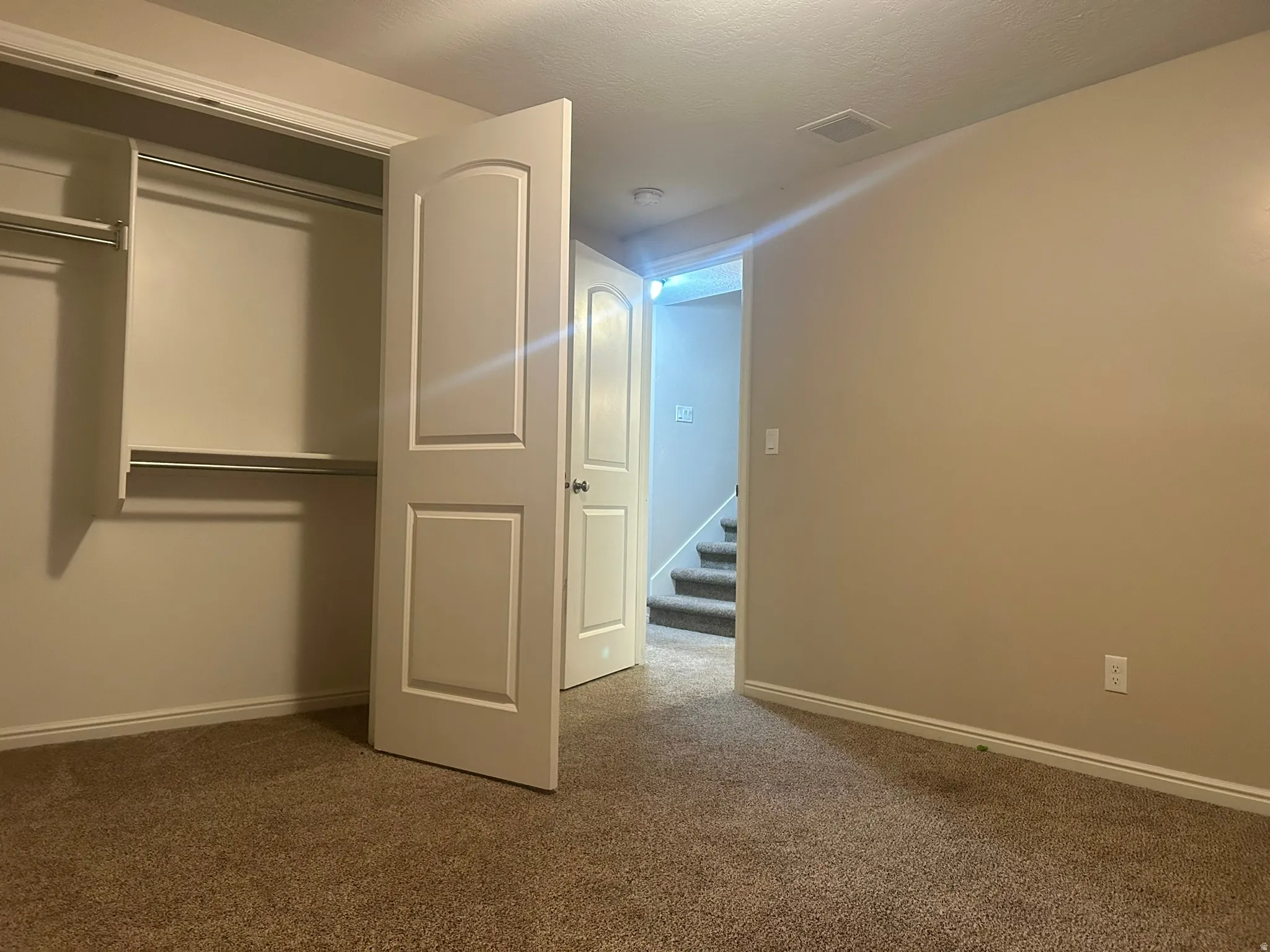 Unfurnished bedroom with carpet flooring and a closet