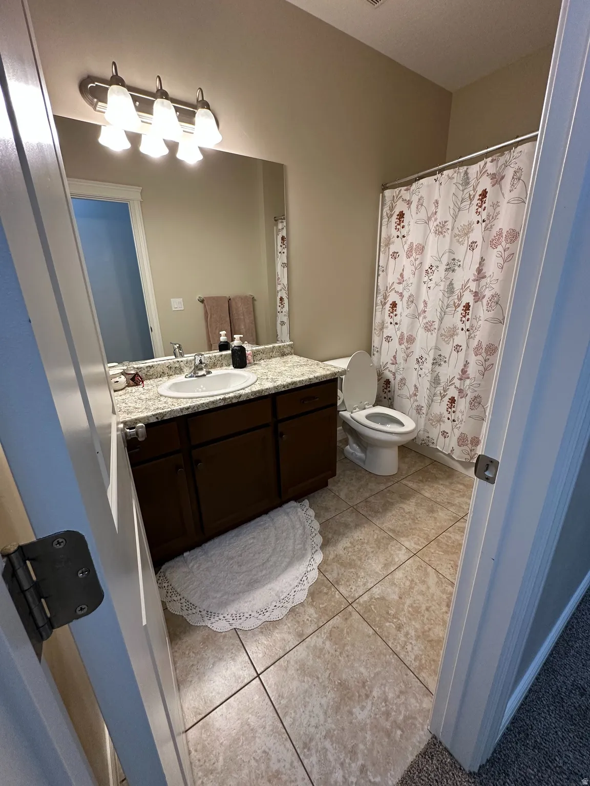 Bathroom featuring vanity, a shower with shower curtain, and light tile patterned floors